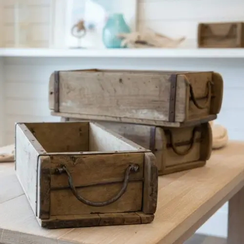 Antique wooden brick molds with iron handles stacked on a table